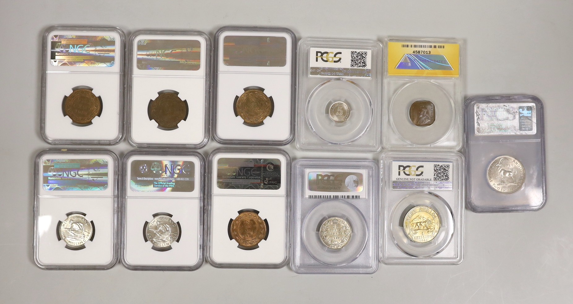 British Empire coins, NGC, PCGS, ANACS slabbed and graded including four Canada 1 cent 1907, 1909, 2 x 1911, 25 cents 1929, two New Zealand 1 shilling 1941 and 1942, Straits Settlements half cent 1932 etc. (11)